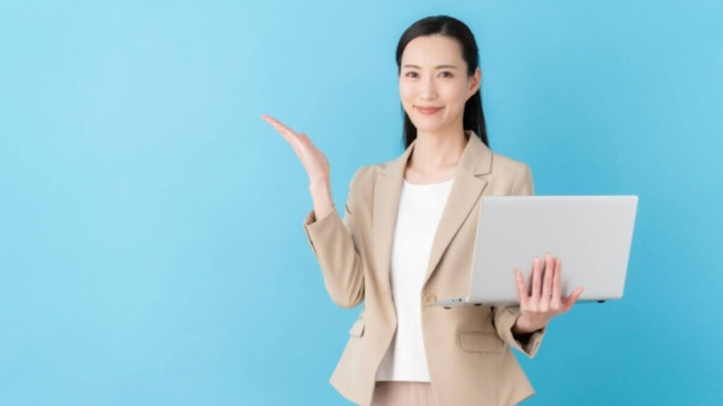 パソコンを片手に案内するスーツ姿の若い女性
