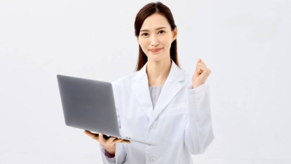 パソコンを片手に笑顔で応援する白衣姿の女性