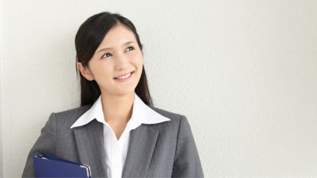 上を見上げ笑顔のスーツ姿の女性